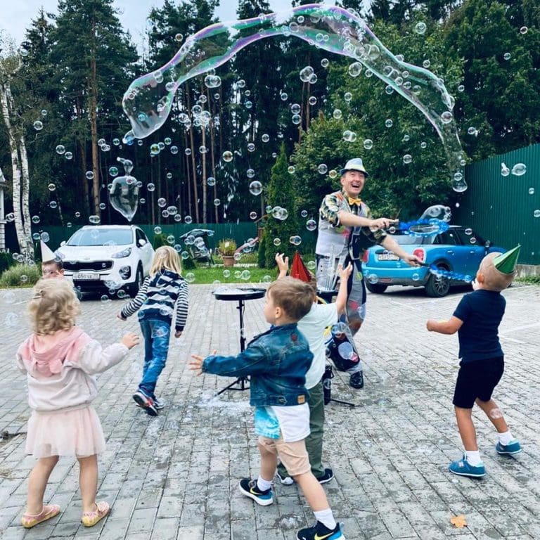 Kinder spielen mit Seifenblasen bei einem Outdoor-Geburtstag